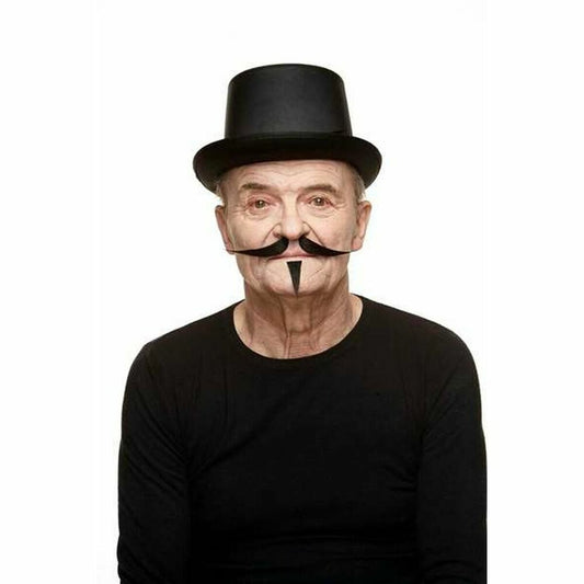 En äldre man bär en svart mustasch i 'V for Vendetta'-stil och en svart hög hatt, båda som tillbehör.