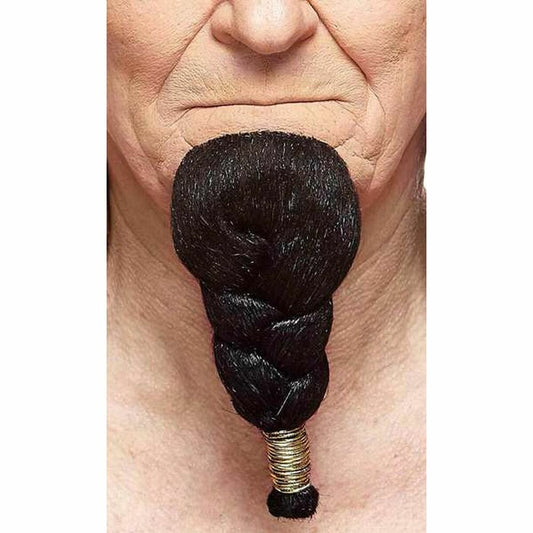 Närbild på en vuxen persons haka där en tjock, svart, flätad hakskäggsaccessoar sitter fast, avslutad med flera tunna guldiga ringar.