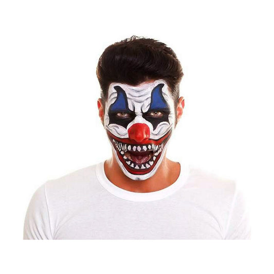 En man visar upp en läskig ansiktsmålning i clownstil med vassa tänder, röd näsa och blå detaljer runt ögonen.