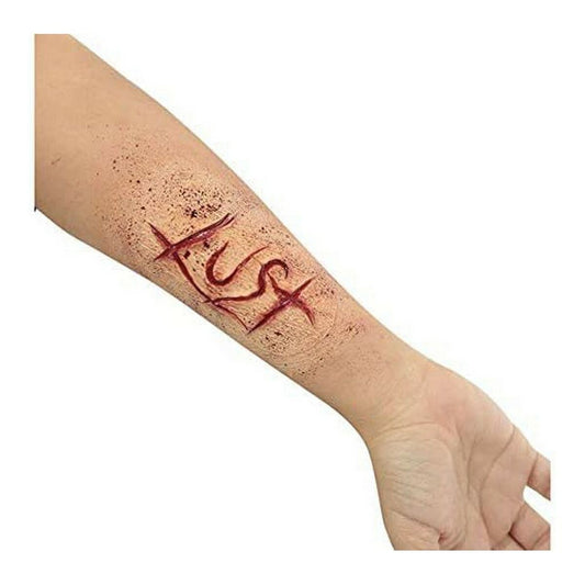 Närbild på en arm där ett realistiskt latex-sår med röda snitt och blodstänk applicerats på huden.