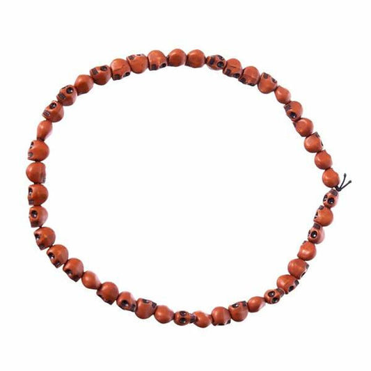 Ett långt halsband med små, bruna och flerfärgade skallepärlor som ligger format som en båge mot en vit bakgrund.