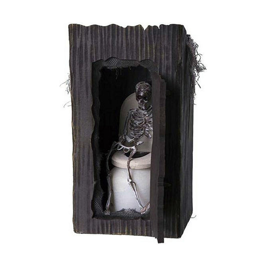 En halloween-dekoration som visar ett skelett som sitter på en toalett inuti en mörk, träliknande bod med öppen dörr och inbyggt ljus.