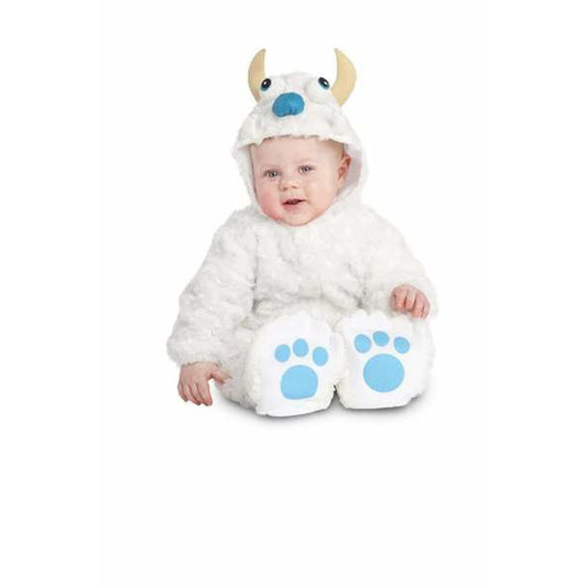 En liten bebis sitter och ler i en fluffig, vit yeti-maskeraddräkt med blåa tassar på fötterna och små horn på luvan.