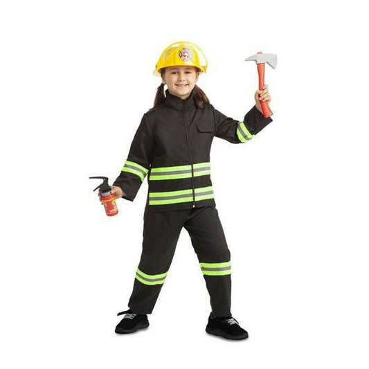 Ett leende barn i en svart brandmansdräkt med neongröna reflexband, bärande en gul hjälm, en leksaksyxa och en liten brandsläckare.