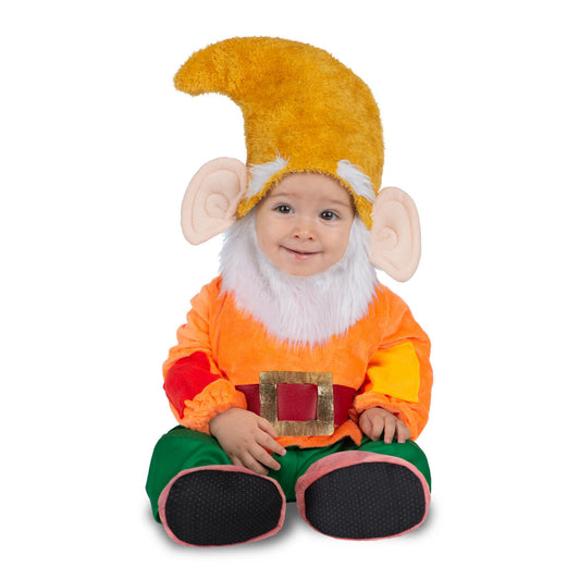 En glad bebis sitter i en färgglad dvärgdräkt med orange tröja, gröna byxor, en stor gul hatt med öron och vitt pälsskägg.