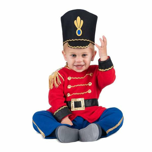 En glad baby sitter klädd i en röd harlekin- eller soldatdräkt med blå byxor och en hög svart hatt med gulddetaljer.