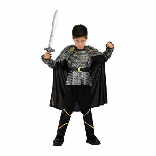 Ett ungt barn i en svart och grå vikingadräkt som håller upp ett silverfärgat leksakssvärd i ena handen och knyter den andra handen i en näve.