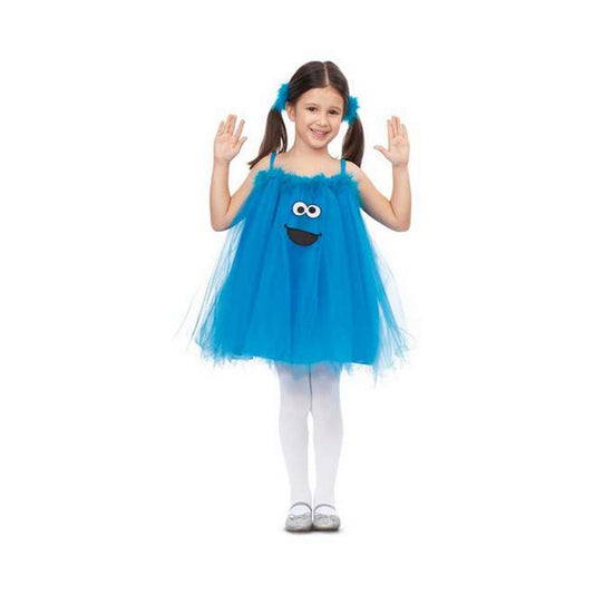 Ett glatt barn som bär en ljusblå, fluffig Cookie Monster-dräkt med ett stort leende och vita strumpbyxor.