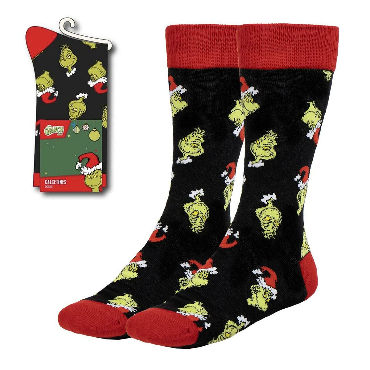 Ett par svarta strumpor med ett mönster av den gröna karaktären Grinch i tomteluva, med röda tår och muddar, visas bredvid sin förpackning.