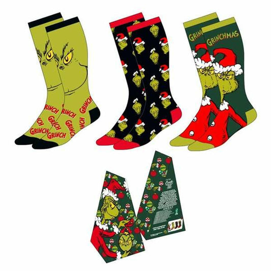 Ett set med tre par knähöga julstrumpor med motiv av karaktären Grinch, inklusive ett par med ett stort ansikte, ett par med mönster och ett par som avbildar Grinch i tomtedräkt.