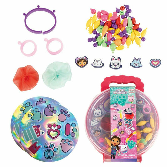 Ett Gabby's Dollhouse smyckesset som innehåller en genomskinlig bärbar väska med handtag, olika färgglada pärlor i form av katter och Gabby, pärlband/armband, samt klistermärken med tassavtryck.