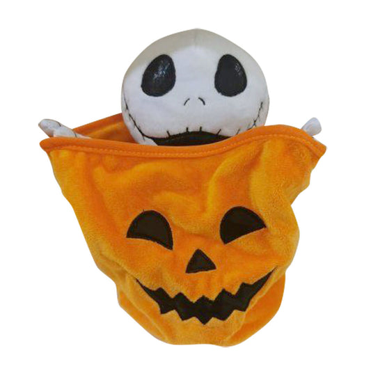 En mjuk, plyschig halloweenprydnadsfigur där ett vitt skeletthuvud med stora svarta ögon kikar upp ur en lysande orange pumpapåse med ett grinande ansikte.