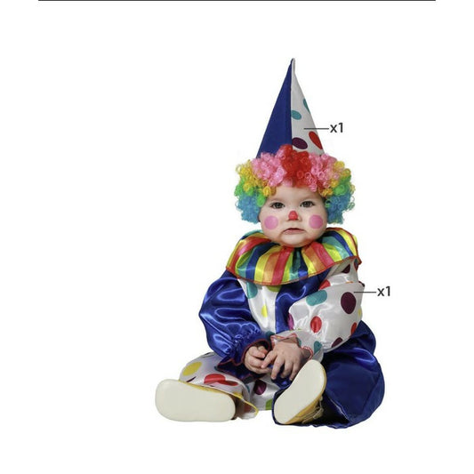 En söt bebis sitter i en färgglad blå och vit clowndräkt med prickar, en regnbågsfärgad peruk och en konformad hatt.