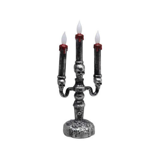 En silverfärgad, gotisk ljusstake i Halloween-stil med tre armar, där varje arm håller ett flammande LED-ljus och dekorerad med dödskallar.