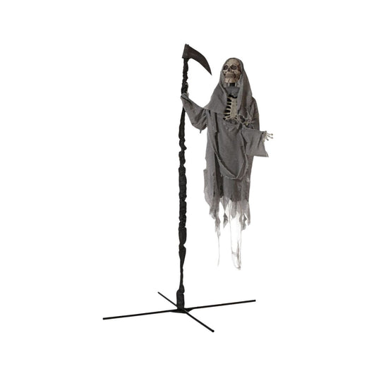 En upprättstående halloweendekoration som föreställer en spökfigur, Underjordens Herre, med ett skeletthuvud och en sliten grå tygdräkt, hållandes en lie med ett vridet svart skaft, monterad på ett svart korsformat stativ.