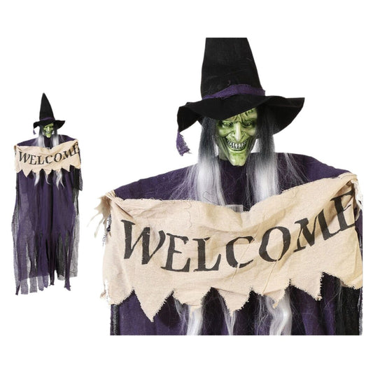 En hängande Halloween-dekoration föreställande en lång, skräckinjagande häxa med grönt ansikte, långt vitt hår, svart hatt och en trasig välkomstskylt.