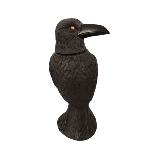 En svart skrämmande korpdekoration med glödande röda ögon och ett gevär i näbben som är avsedd för Halloween.