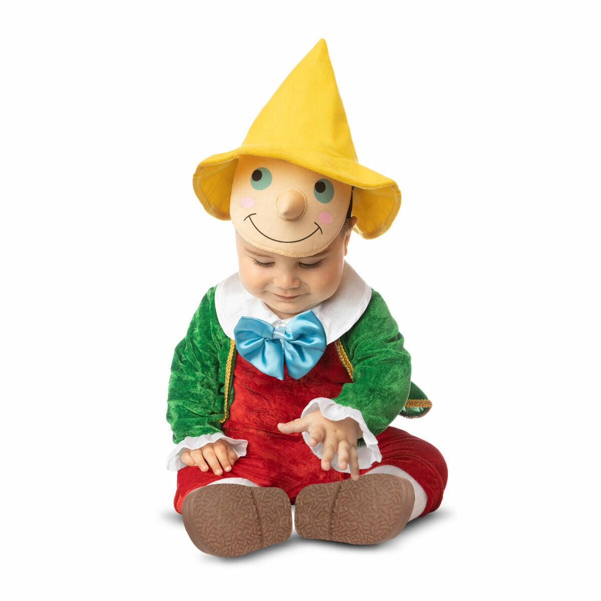 En bebis sitter i den söta Pinocchio-dräkten och tittar ner.