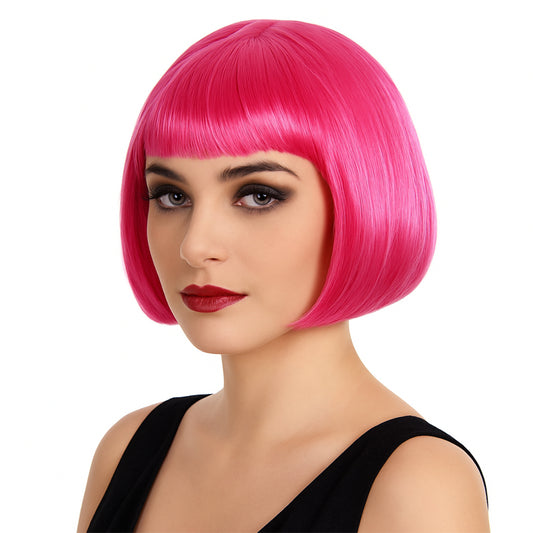 Närbild på en kvinna med en intensivt cerise/rosa, kortklippt bob-peruk med rak lugg.