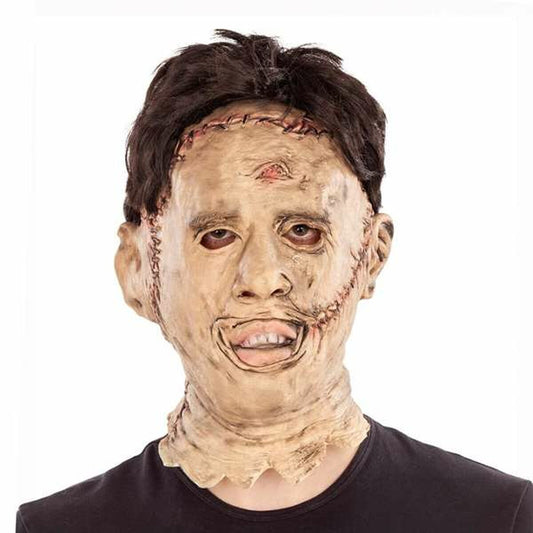 En person bär en obehaglig, Brutal Motorsågsmördare Mask i latex, som föreställer ett ihopsytt ansikte med ärr och stygn.