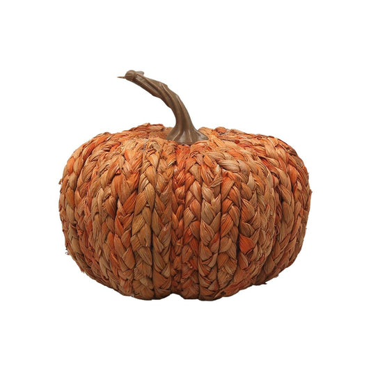 En liten, charmig och rustik pumpa gjord av flätat orange strå med en brun, snirklig stjälk.