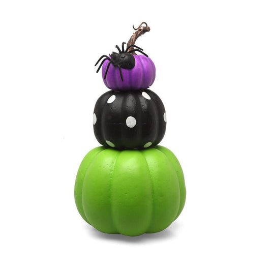 En Halloweendekoration som föreställer tre staplade pumpor i olika färger och mönster, med en liten spindel på toppen.