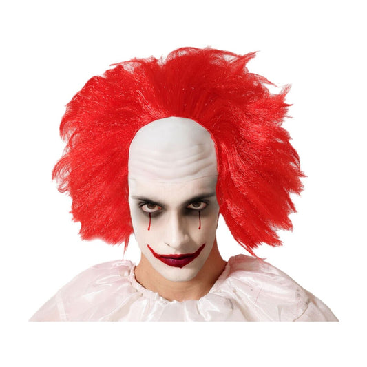 Man sminkad som en läskig clown bär en röd peruk med kal flint och stirrar intensivt mot kameran.