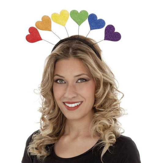 Leende kvinna bär ett diadem dekorerat med glitterhjärtan i regnbågens färger som sticker upp som antenner – perfekt accessoar för Pride eller färgglada temafester.
