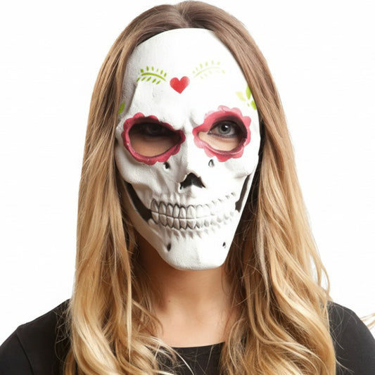 En kvinna med långt blont hår bär en elegant vit Day of the Dead dödskallemask med rosa dekorationer runt ögonen.