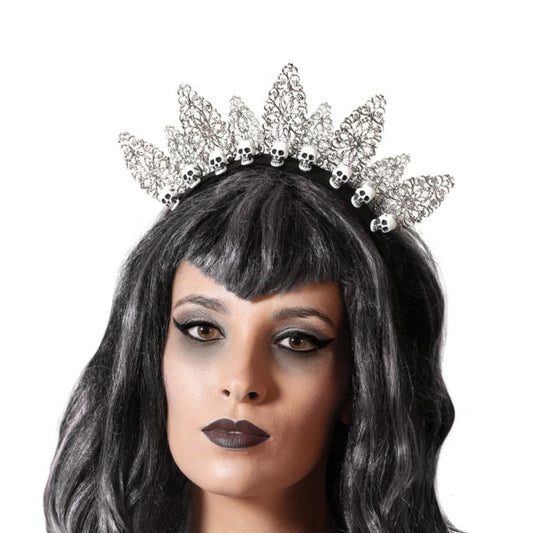 En kvinna med mörkt smink bär en Elegant Gotisk Dödskalle-Tiara med silverfärgade blad och små dödskallar.