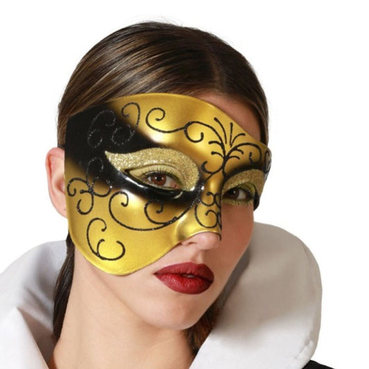 En kvinna med mörkt hår och röda läppar bär en elegant, guld- och svartfärgad venetiansk ögonmask med snirkliga, glittriga mönster.