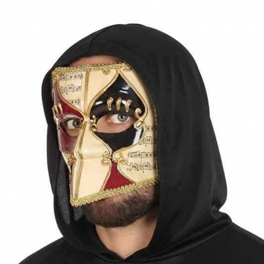 En vacker, Elegant Venetiansk Harlekinmask med ett rutmönster i rött, svart och guld, dekorerad med noter bärs av en man i svart kåpa.