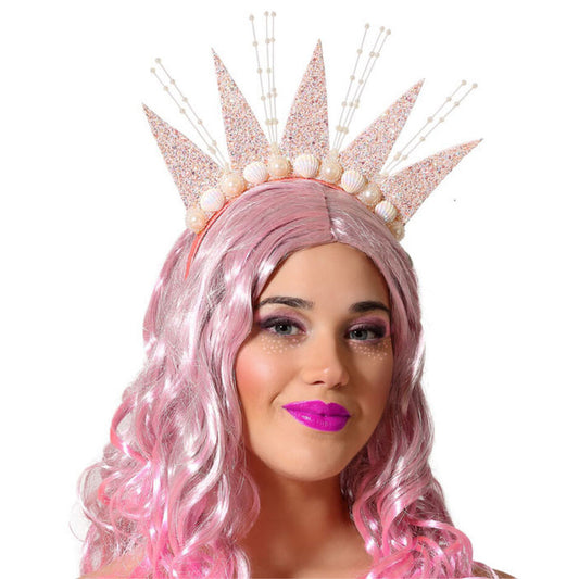 Närbild på en kvinna med rosa hår som bär en episk, glittrande havsgudinna-krona dekorerad med snäckskal och pärlor.