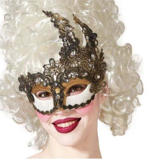 En leende kvinna med en stor, vit barockperuk bär en detaljerad och extravagant ögonmask i svart och guld spets, dekorerad med pärlor och gnistrande juveler.