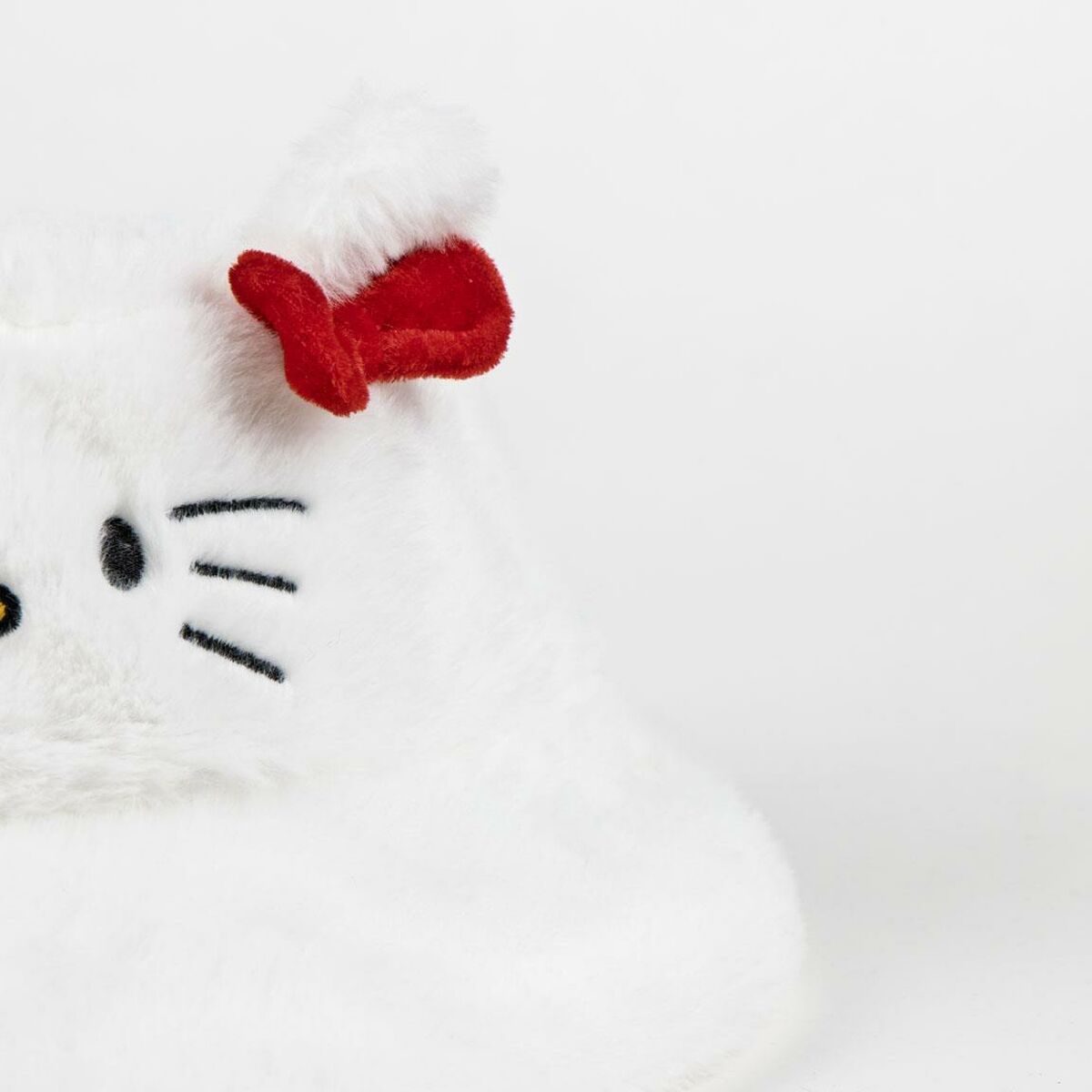 En närbild på ett av de fluffiga, vita öronen med den klassiska röda rosetten på Hello Kitty-hatten.