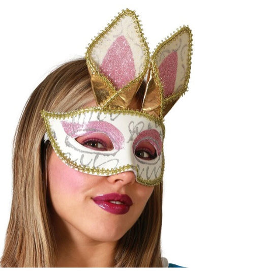 En kvinna bär en söt, vit ögonmask med glittriga detaljer och stora, stående kaninöron i guld och rosa.