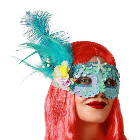 En kvinna med rött hår bär en Förtrollande Blå Sjöjungfrumask med paljetter, en sjöstjärna och en stor turkos fjäderplym.