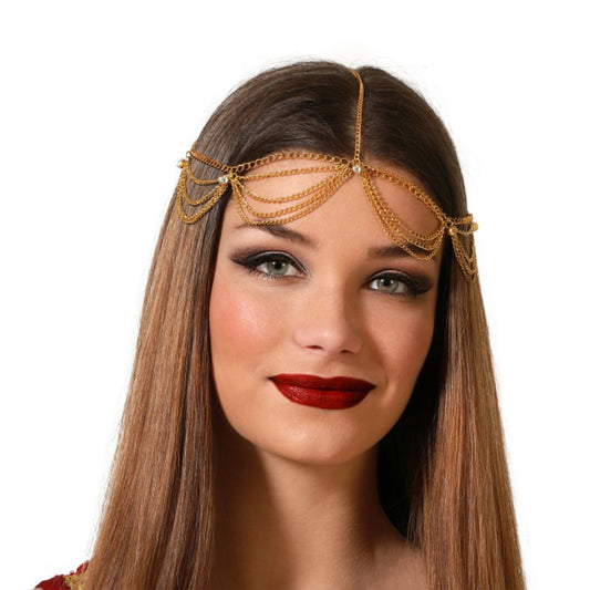 En kvinna med mörkt, rakt hår och dramatisk makeup bär det gyllene huvudsmycket som vilar över hennes panna och hårfäste.