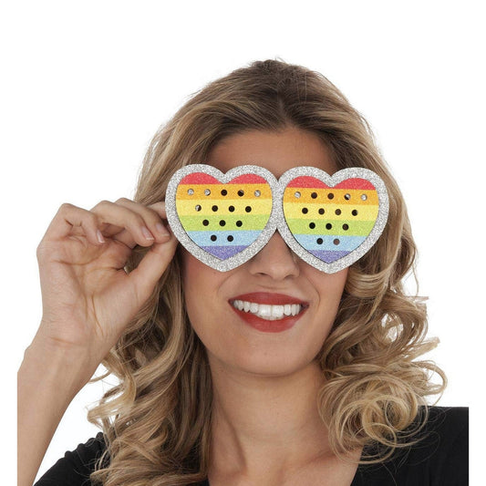 Närbild på en leende kvinna som bär hjärtformade glasögon med glitterkant och regnbågsfärger, perfekta för pride eller fest med kärlekstema.