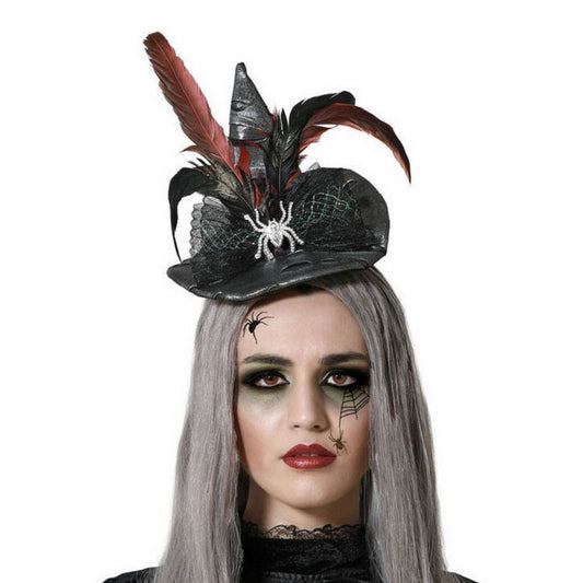 Närbild på en kvinna med grått hår och dramatisk sminkning som bär ett diadem med en gotisk mini-häxhatt, dekorerad med fjädrar och en glittrande spindel.
