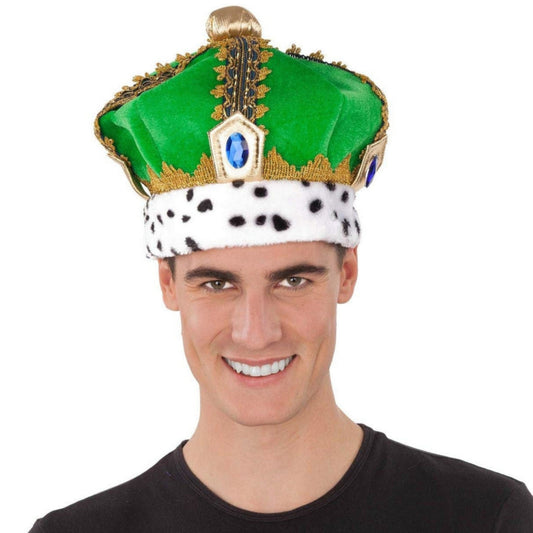 En person bär en grön kungakrona med blå ädelstensdetaljer, guldkant och vit kant med svarta prickar – perfekt för maskerad eller temafest.