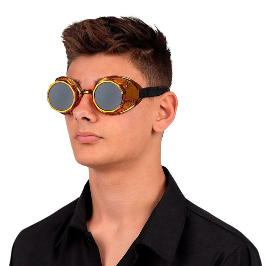 En ung man poserar i ett par stora, gyllene steampunk-goggles med mörka glas och ett svart, elastiskt band.