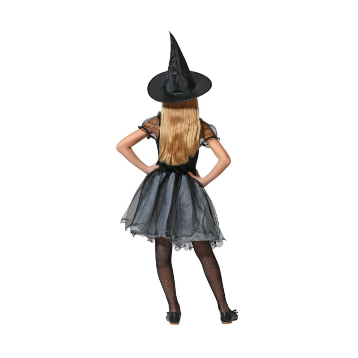 En flicka med långt blont hår ses bakifrån, iklädd en svart häxdräkt med tyllkjol och en spetsig häxhatt, poserande med händerna på höfterna.