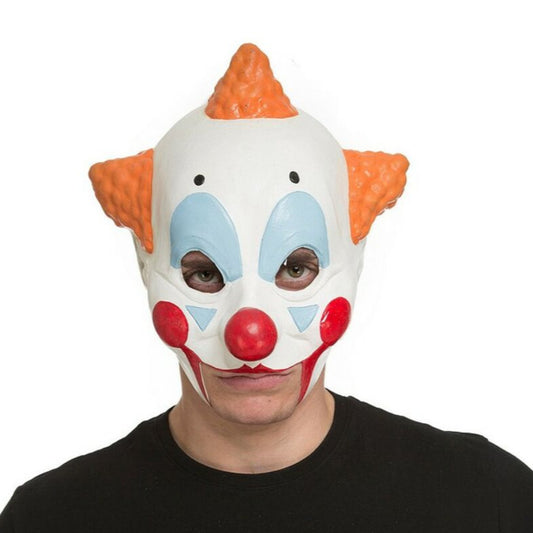 En man bär en ikonisk vit rånar-clownmask med orange hårtofsar och ett neutralt, läskigt uttryck.