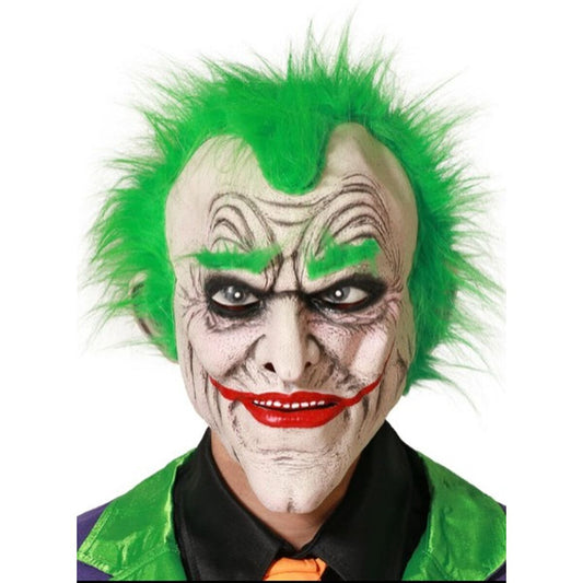Närbild på en skräckinjagande latexmask föreställande en joker med grönt hår, röda läppar och svartsminkade ögon, bärs av en person i lila och grön kostym.