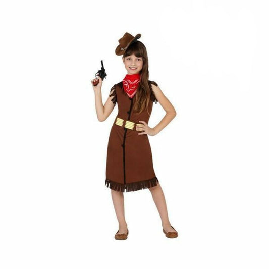 Flicka i en brun fransig cowgirl-klänning med röd halsduk och ett bälte med "kulor", poserande med en cowboyhatt och leksakspistol för en vilda västern-look.