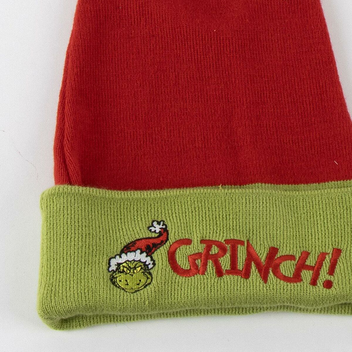 Närbild på den gröna kanten av en Grinchen tomtemössa som visar det broderade ansiktet och texten 'GRINCH!'