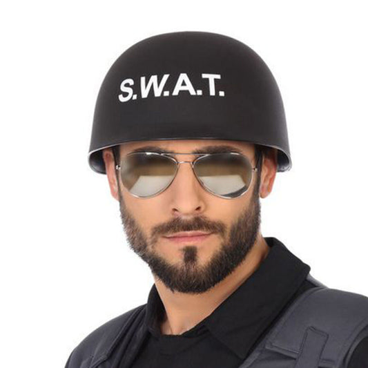 En man med skägg och pilotglasögon bär en kaxig, svart S.W.A.T.-hjälm med vit text.