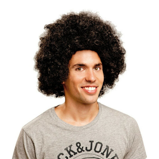 En leende man bär en klassisk, stor och krullig svart afroperuk, redo för 70-talsfest.