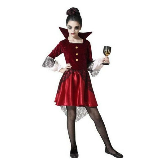 Ett barn klädd i en kunglig, vinröd vampyrdräkt med hög krage och spetsdetaljer, sminkad som en vampyr och håller i en bägare.